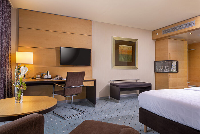 Classic room at Maritim Hotel Düsseldorf with desk, flat-screen TV, stylish decor, and cozy atmosphere.