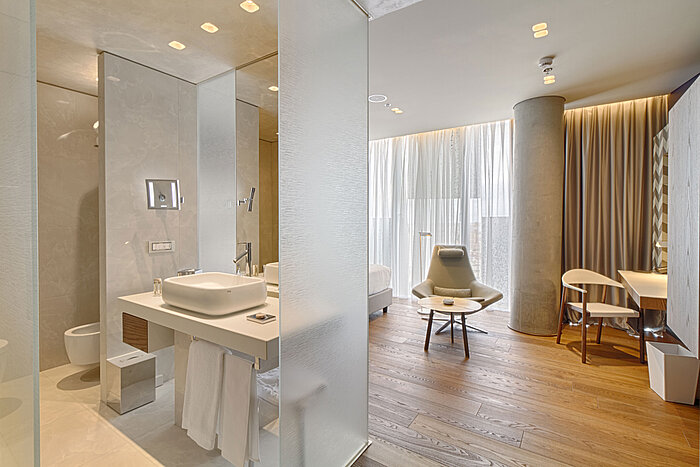 Modern hotel room with open bathroom concept, wooden flooring and design furniture at Maritim Hotel Plaza Tirana