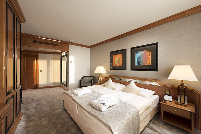 Comfortable bedroom at Maritim Hotel Ulm with double bed, wood accents and bathrobes