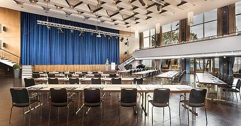 Grand Hall "Maritim" at Maritim Seehotel Timmendorfer Strand with stage, blue curtains, and conference seating.