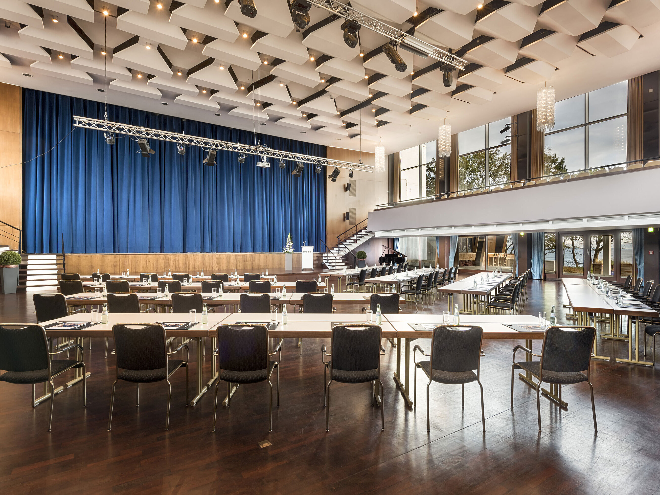 Grand Hall "Maritim" at Maritim Seehotel Timmendorfer Strand with stage, blue curtains, and conference seating.