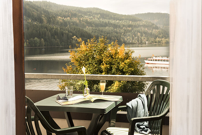 Balcony with table, drink and view of Lake Titisee and nature