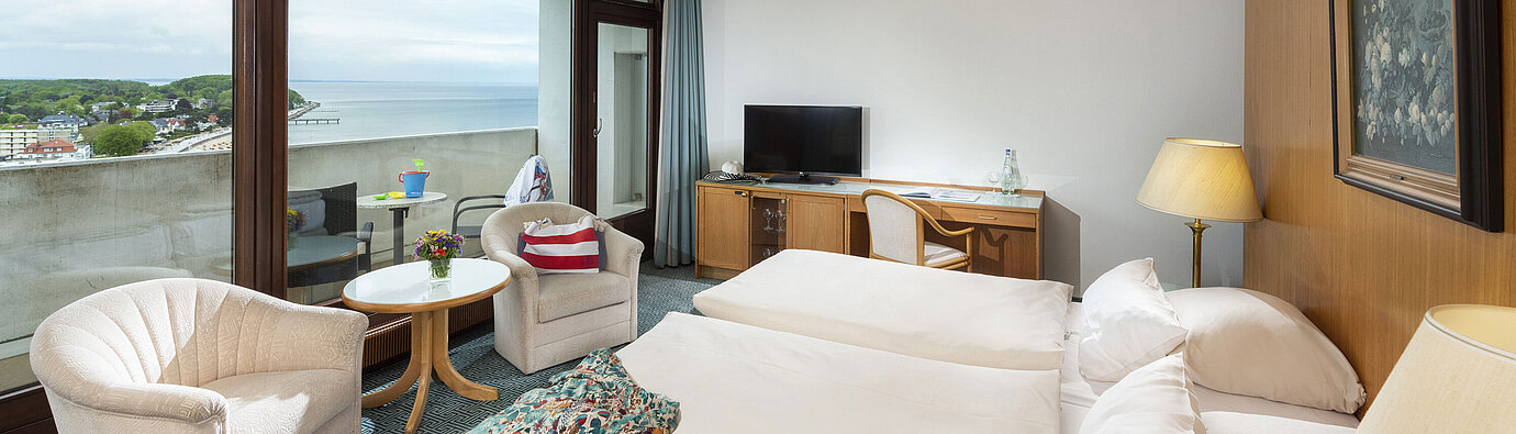 Comfortable room with two armchairs and sea view balcony at Maritim Hotel Travemünde