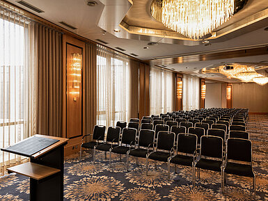 Large conference hall with theatre seating, lectern and chandeliers at Maritim Hotel Ulm.