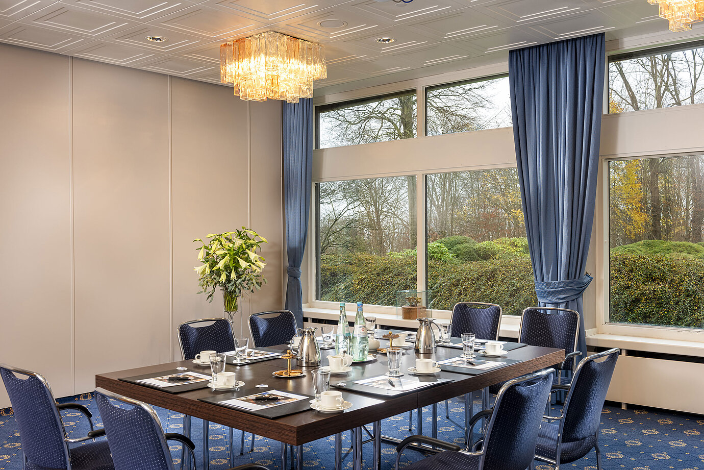 Salon Flensburg in the Maritim Hotel Kiel, conference room with a set table, large windows and stylish lighting.