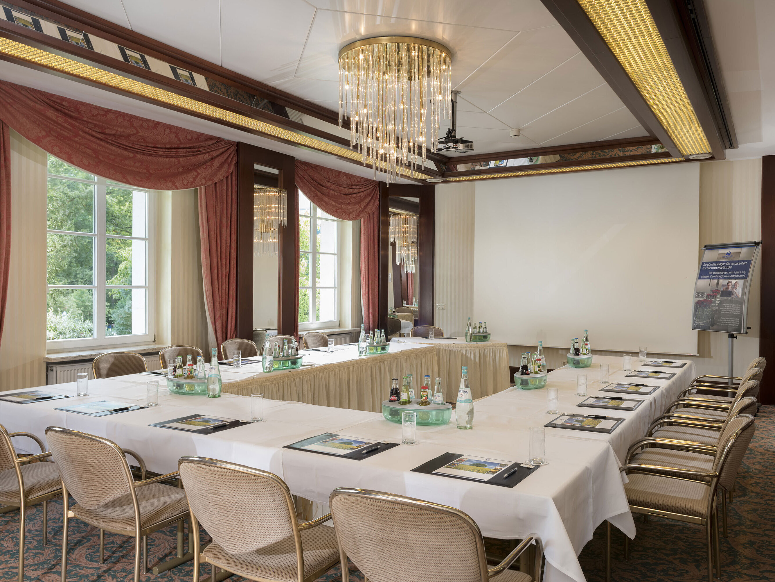 Bright meeting room with U-shape seating, large windows and chandelier at Maritim Hotel Bad Wildungen