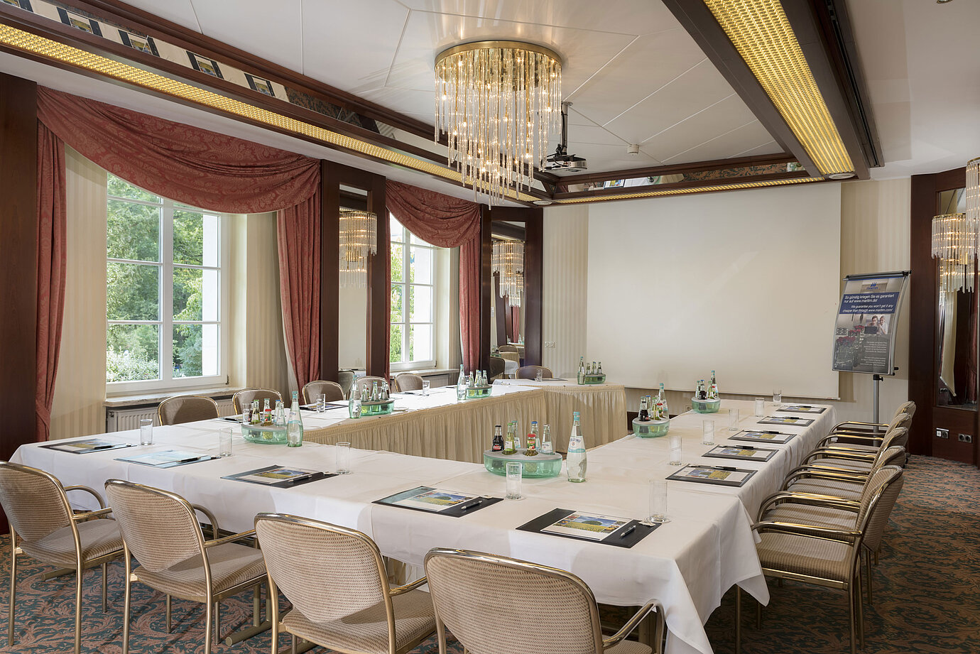 Bright meeting room with U-shape seating, large windows and chandelier at Maritim Hotel Bad Wildungen