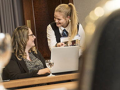A Maritim Hotel Bonn employee assists a participant during a meeting in Salon Rheinaue.