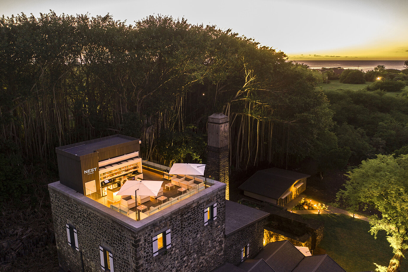 A stylish hotel rooftop terrace with comfortable seating and breathtaking sunset views