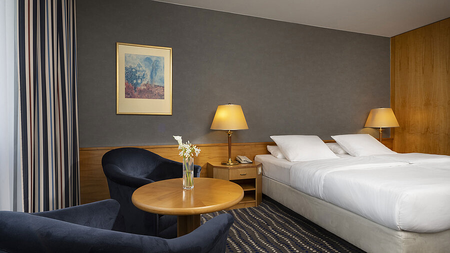 Hotel room with double bed, cozy seating area, and stylish decor, perfect for relaxation