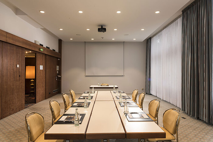 "Salon Bonn" conference room at Maritim Seehotel Timmendorfer Strand with meeting table, natural light, and screen.