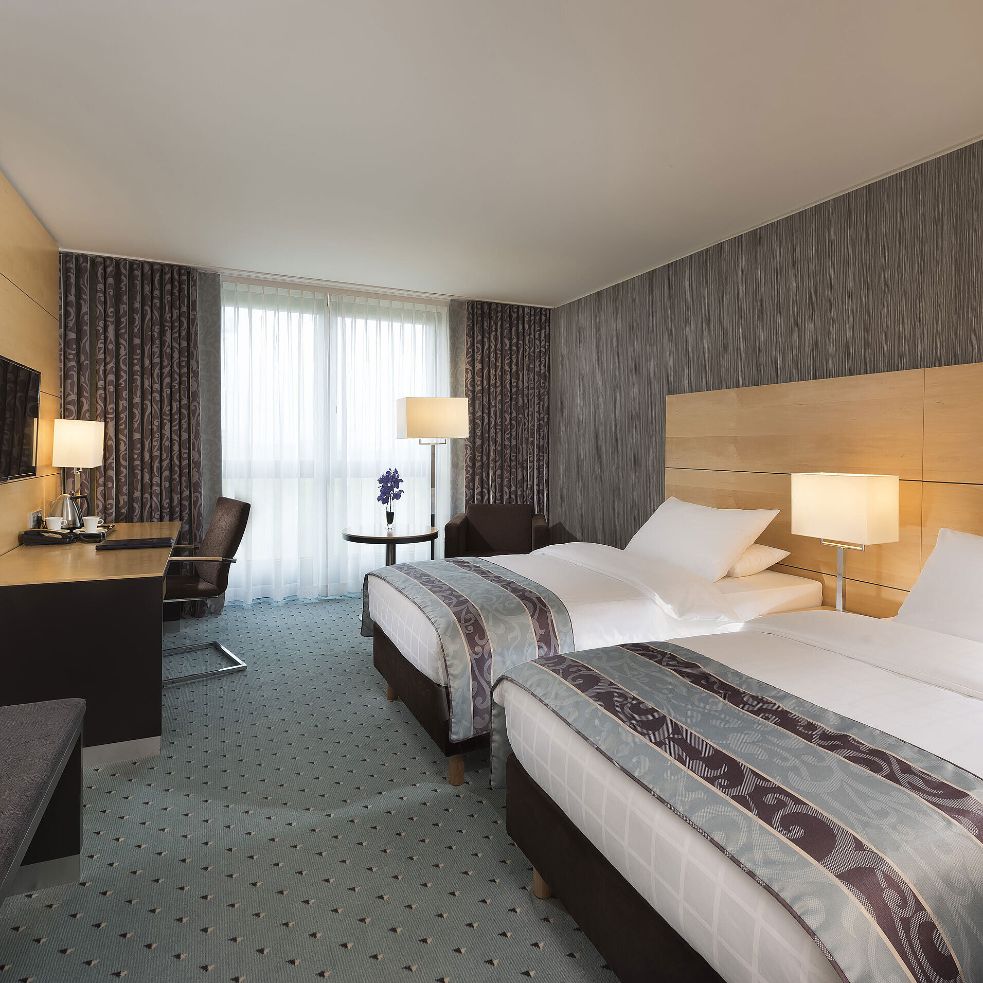 Modern Classic Twin room at Maritim Hotel Düsseldorf with twin beds, desk, and floor-to-ceiling window.