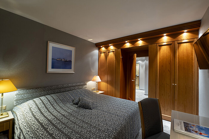 Bedroom of the Grand Suite at Maritim Hotel Kiel with stylish design, large bed, and elegant lighting.