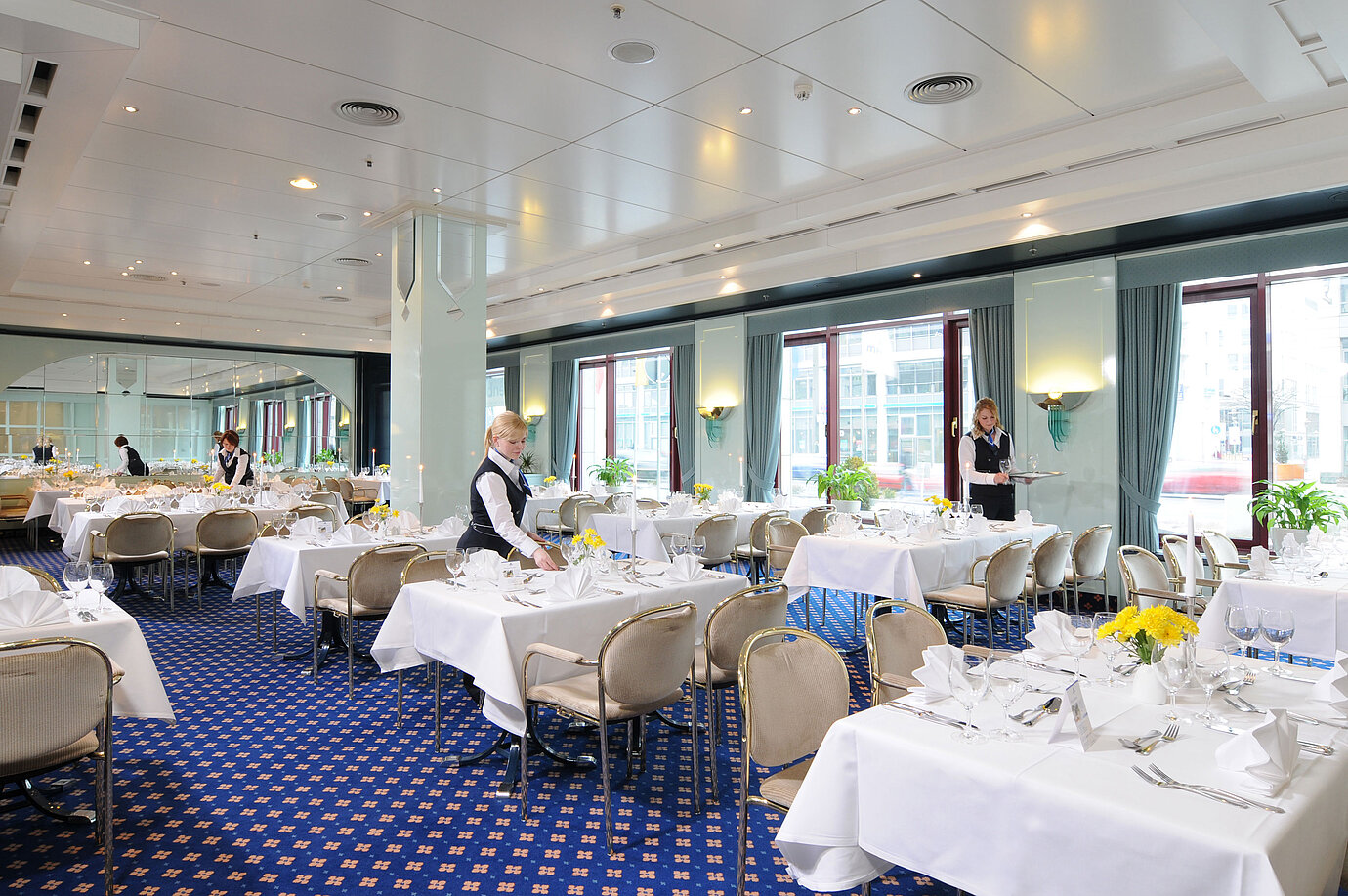 Salon Bonn conference room at Maritim Hotel Magdeburg with white-clothed tables, elegant décor, and friendly service staff.