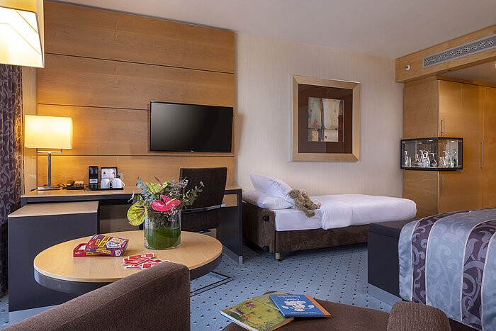 Superior family room at Maritim Hotel Düsseldorf with extra bed, desk, and cozy atmosphere.