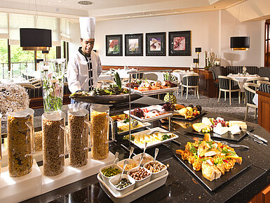 Breakfast buffet at Maritim Hotel Bad Homburg with fresh dishes, cereals and a friendly chef.