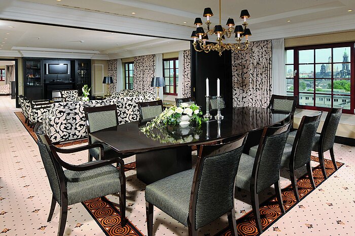 Presidential suite at the Maritim Hotel Dresden with elegant dining table, luxurious decor, and city view.