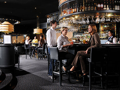 Guests enjoying drinks and conversation at the stylish bar of Maritim Hotel Munich