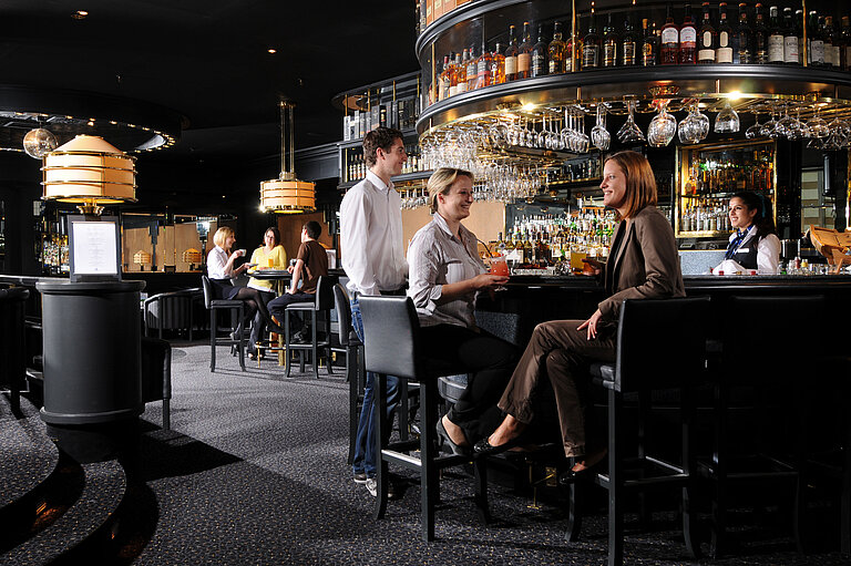Guests enjoying drinks and conversation at the stylish bar of Maritim Hotel Munich