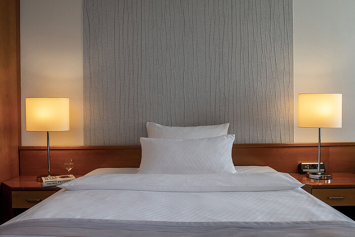 Modern superior room with stylish bed, nightstands, and soft lighting at Maritim Hotel Hannover.