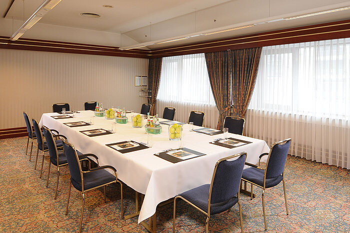 Bright meeting room with U-shaped seating and fresh decor at Maritim Hotel Magdeburg.