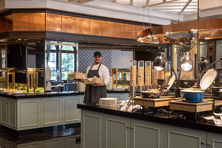 Staff member at the breakfast buffet in Restaurant Landgraf, Maritim Hotel Darmstadt, with fresh pastries