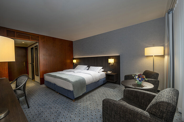 Modernly furnished Classic room with desk, TV, seating area, and comfortable bed at Maritim Hotel Bremen.