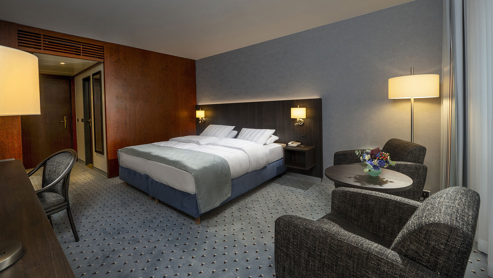 Modernly furnished Classic room with desk, TV, seating area, and comfortable bed at Maritim Hotel Bremen.