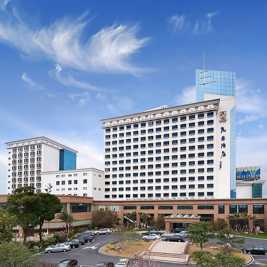 酒店外觀呈現高聳立面，現代化擴建部分與周圍綠意相映成趣，營造出賓至如歸的氛圍。