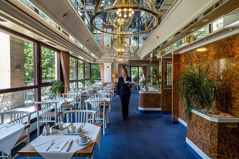 Restaurant at Maritim Hotel Köln with staff and large windows overlooking greenery