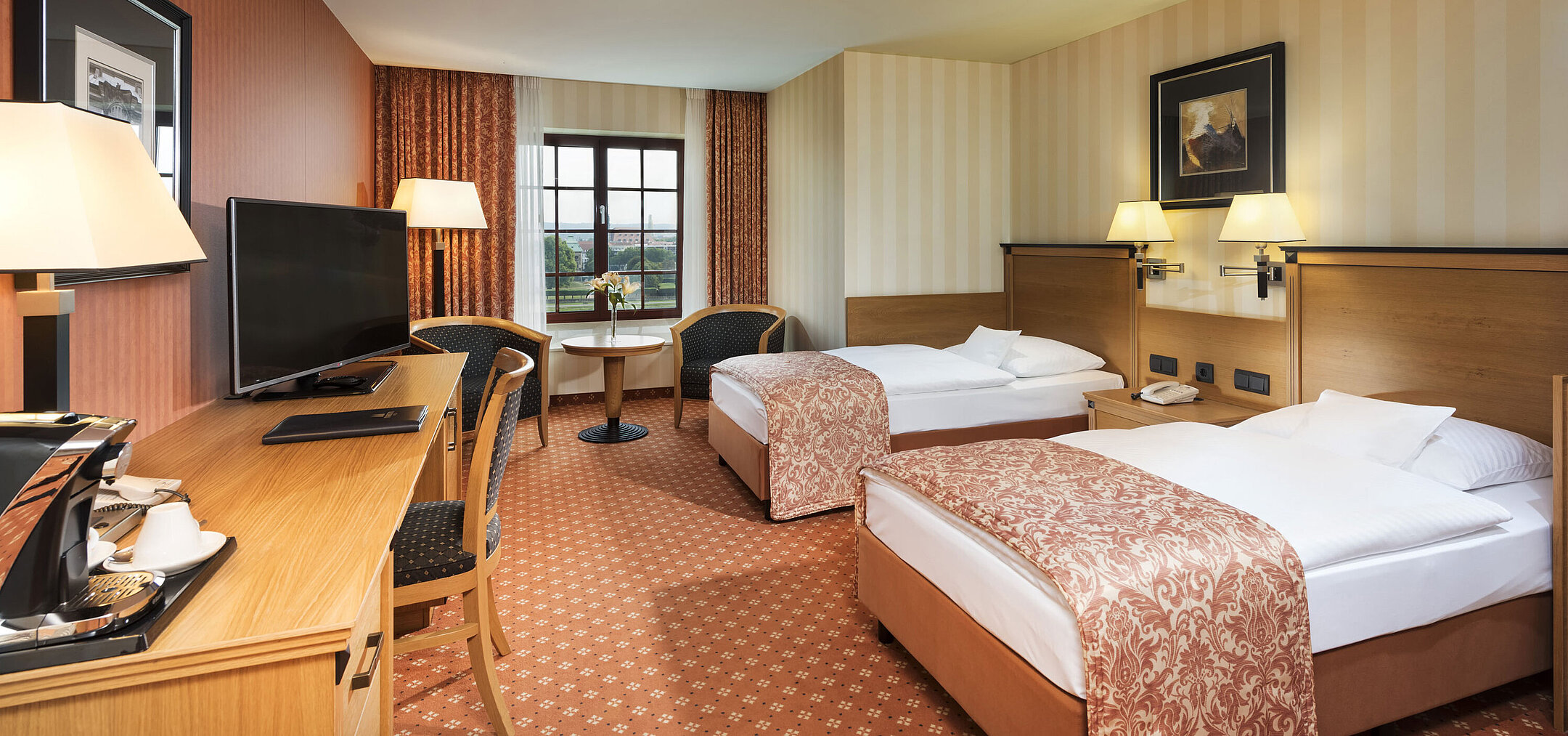Superior room at Maritim Hotel Dresden with two single beds, desk, TV, and a view of the Elbe River.