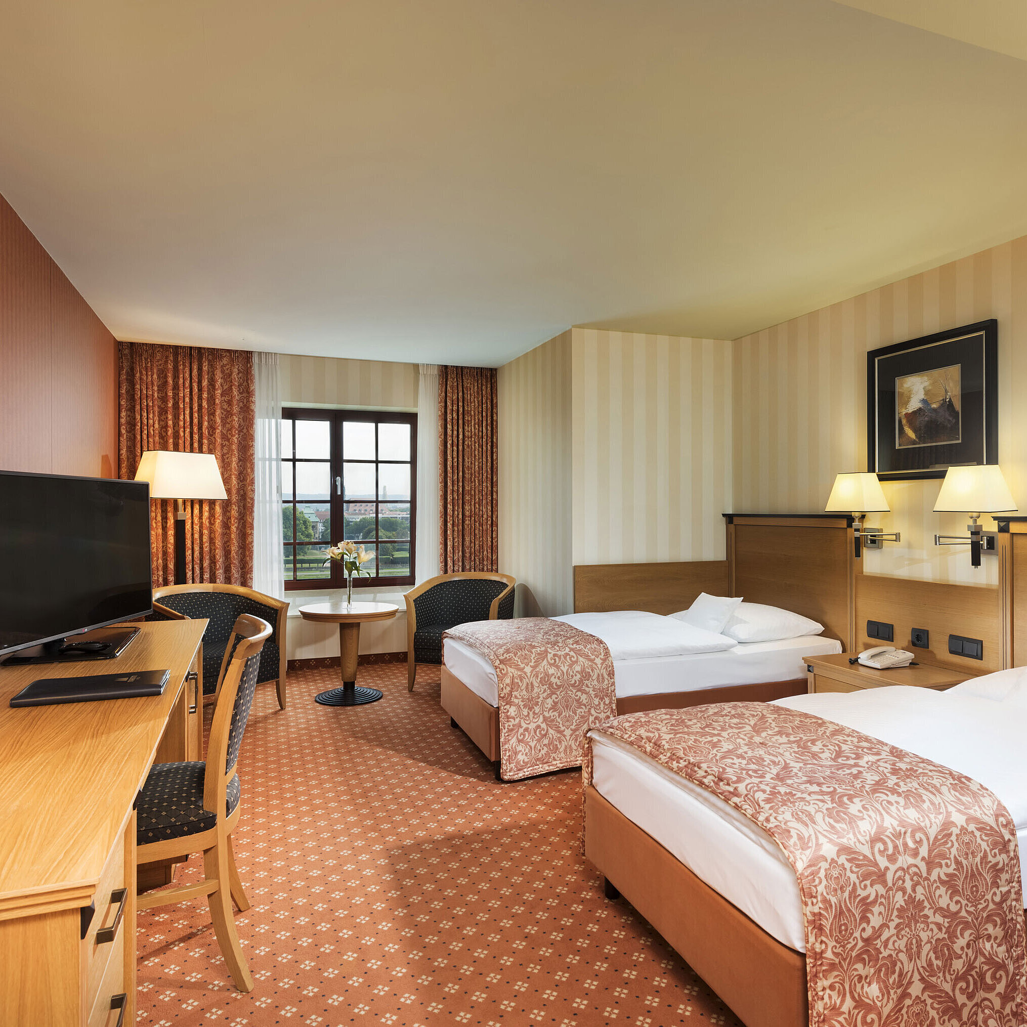 Superior room at Maritim Hotel Dresden with two single beds, desk, TV, and a view of the Elbe River.