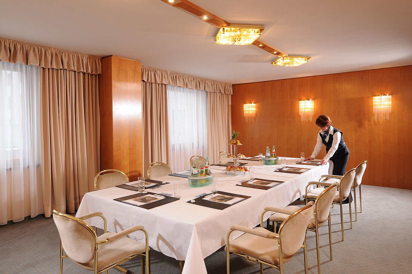 Stylish conference room in Maritim Hotel Magdeburg with a set table and service.