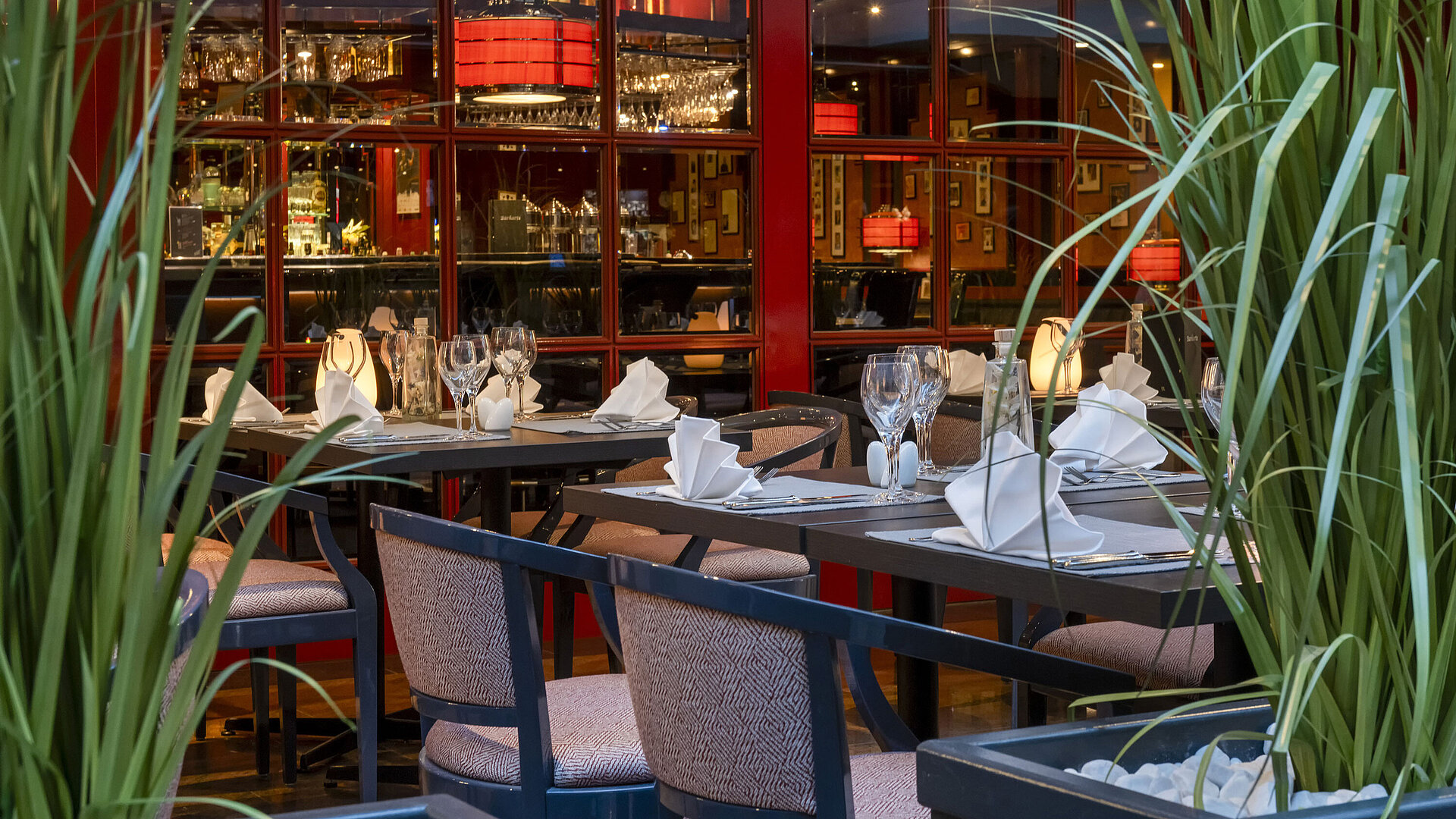 Stylishly set bistro at the Maritim Hotel Magdeburg with a friendly staff member preparing the tables.