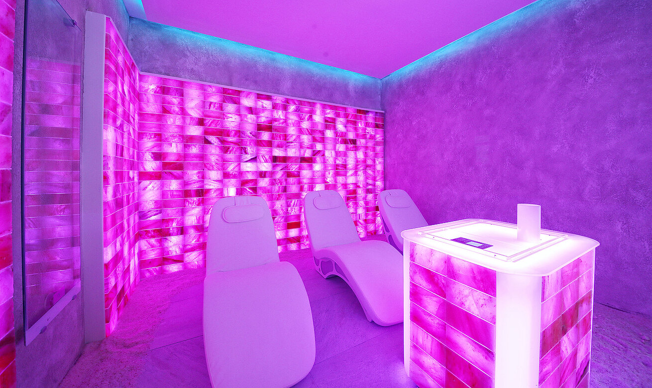 Modern salt room in the spa with illuminated salt walls and relaxation loungers