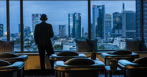 Guest enjoying the panoramic view of Frankfurt’s skyline in the Sky Lounge at Maritim Hotel Frankfurt.