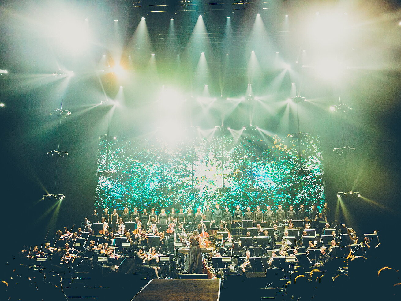Night of the Proms Large orchestra and choir on stage with light effects during concert performance