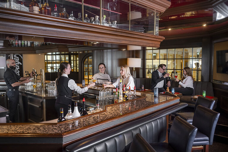 Guests enjoying cocktails at the bar of the Maritim Hotel Würzburg.