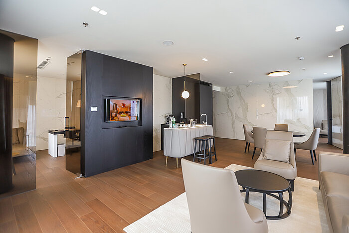 Spacious suite with seating area, kitchenette and TV at the Maritim Hotel Plaza Tirana