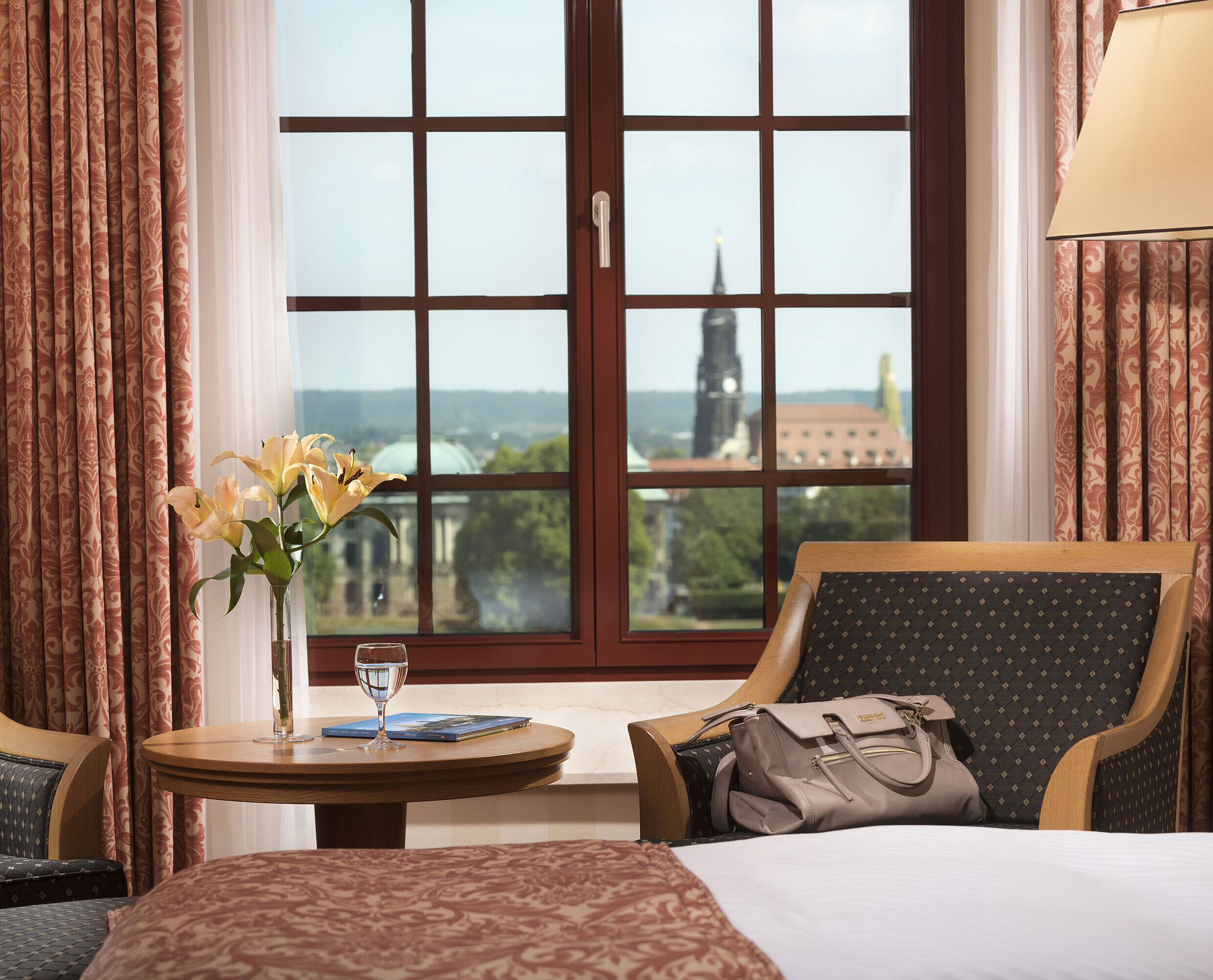 Seating area in the Superior room at Maritim Hotel Dresden with a window view of the historic old town.