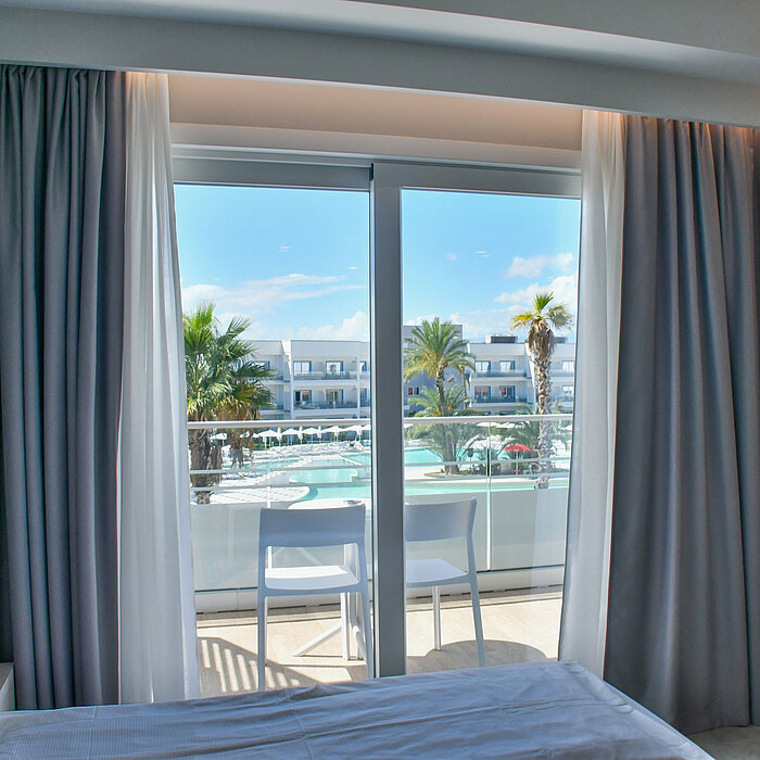 View from hotel balcony at Maritim Resort Calabria with pool, palm trees and modern resort