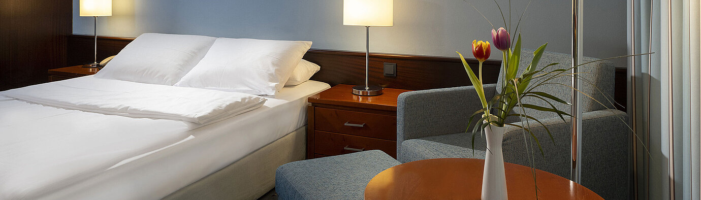 Comfortable single room with queen-size bed, modern furniture, and ambient lighting at the Maritim Hotel Darmstadt.