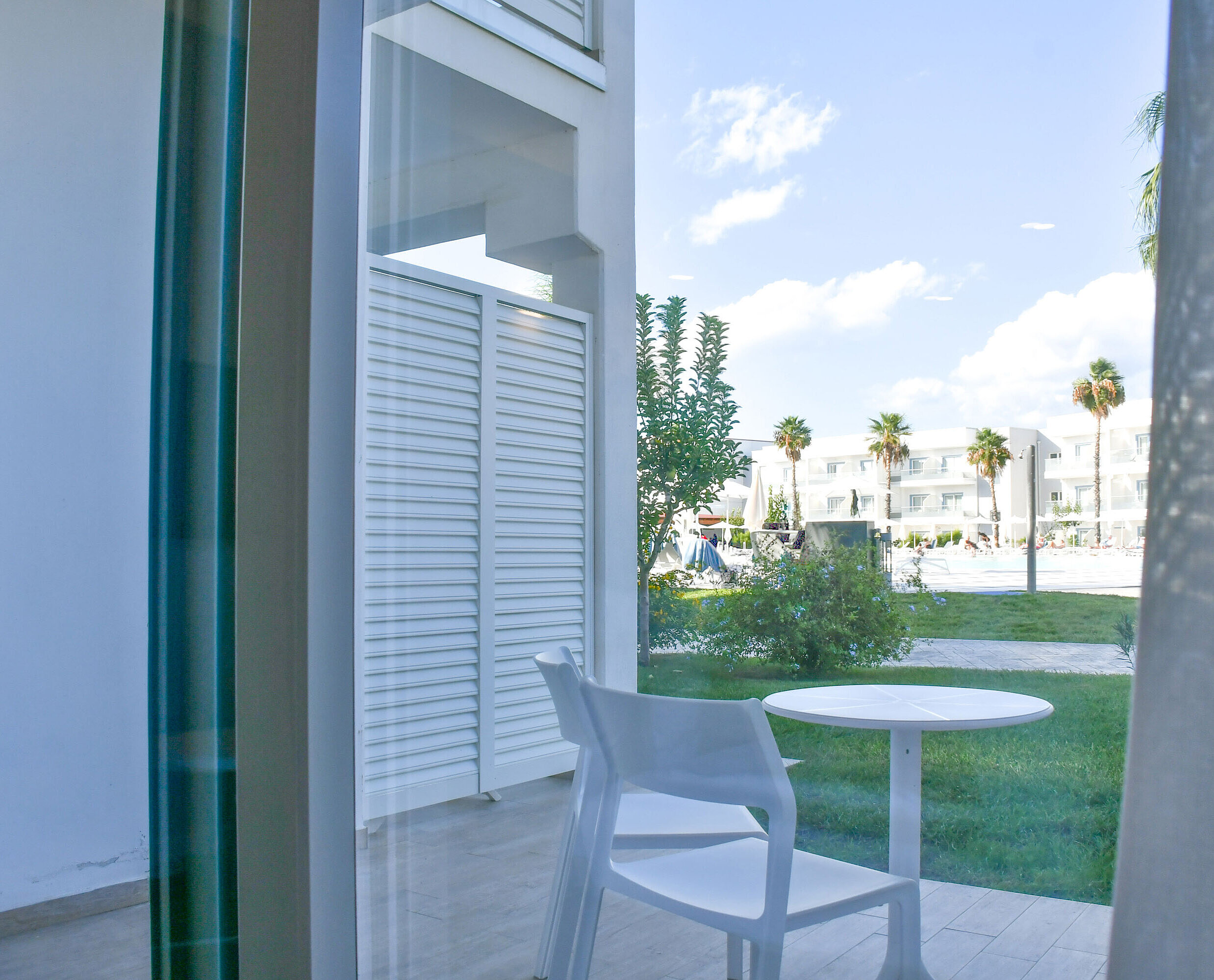 Private terrace with table and chairs at Maritim Resort Calabria with view of garden and pool
