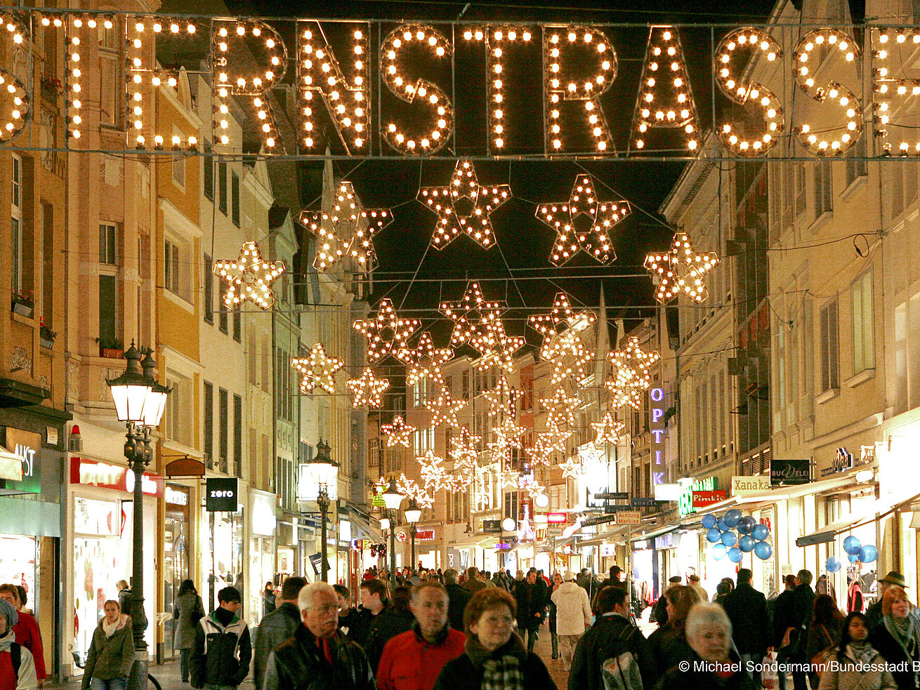 Festively lit shopping street with stars and “Sternenstraße” sign in Bonn city centre