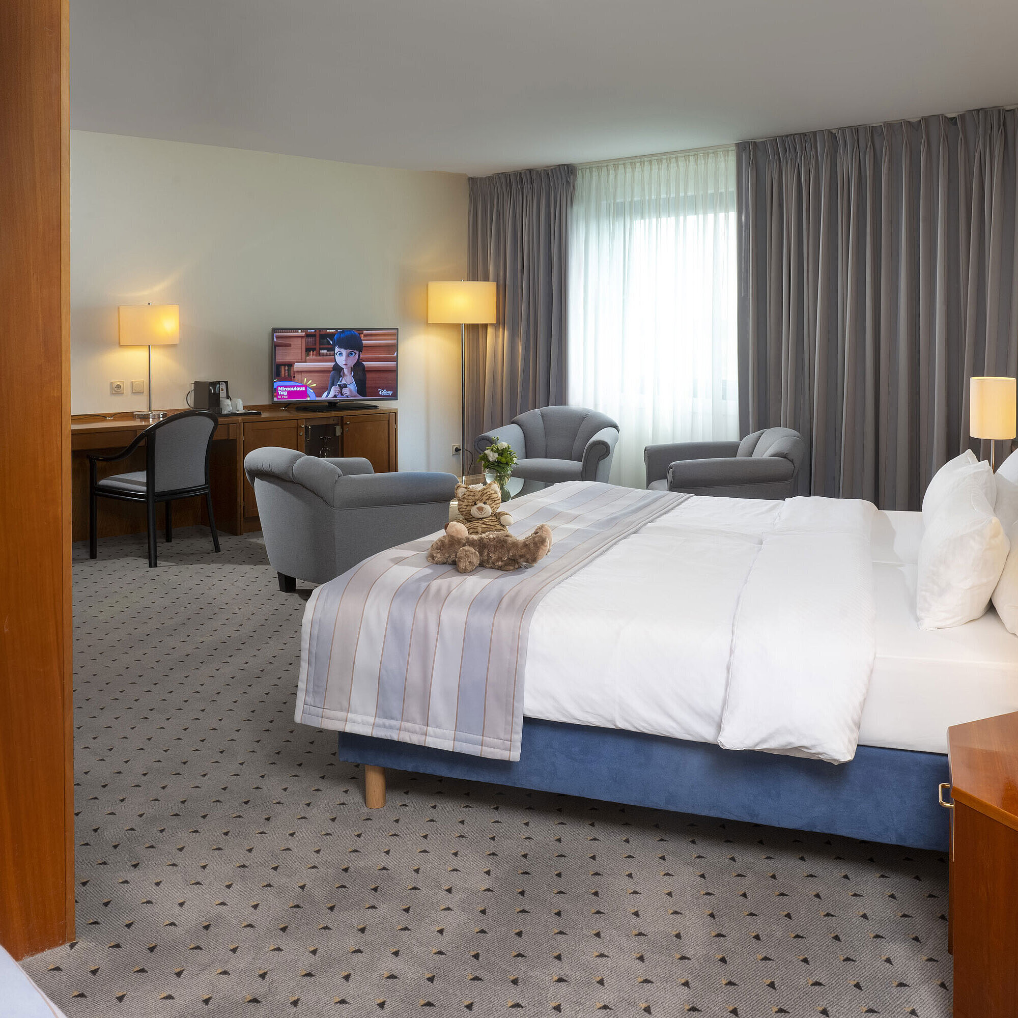 Spacious room at Maritim Hotel Hannover with double bed, seating area, and TV.