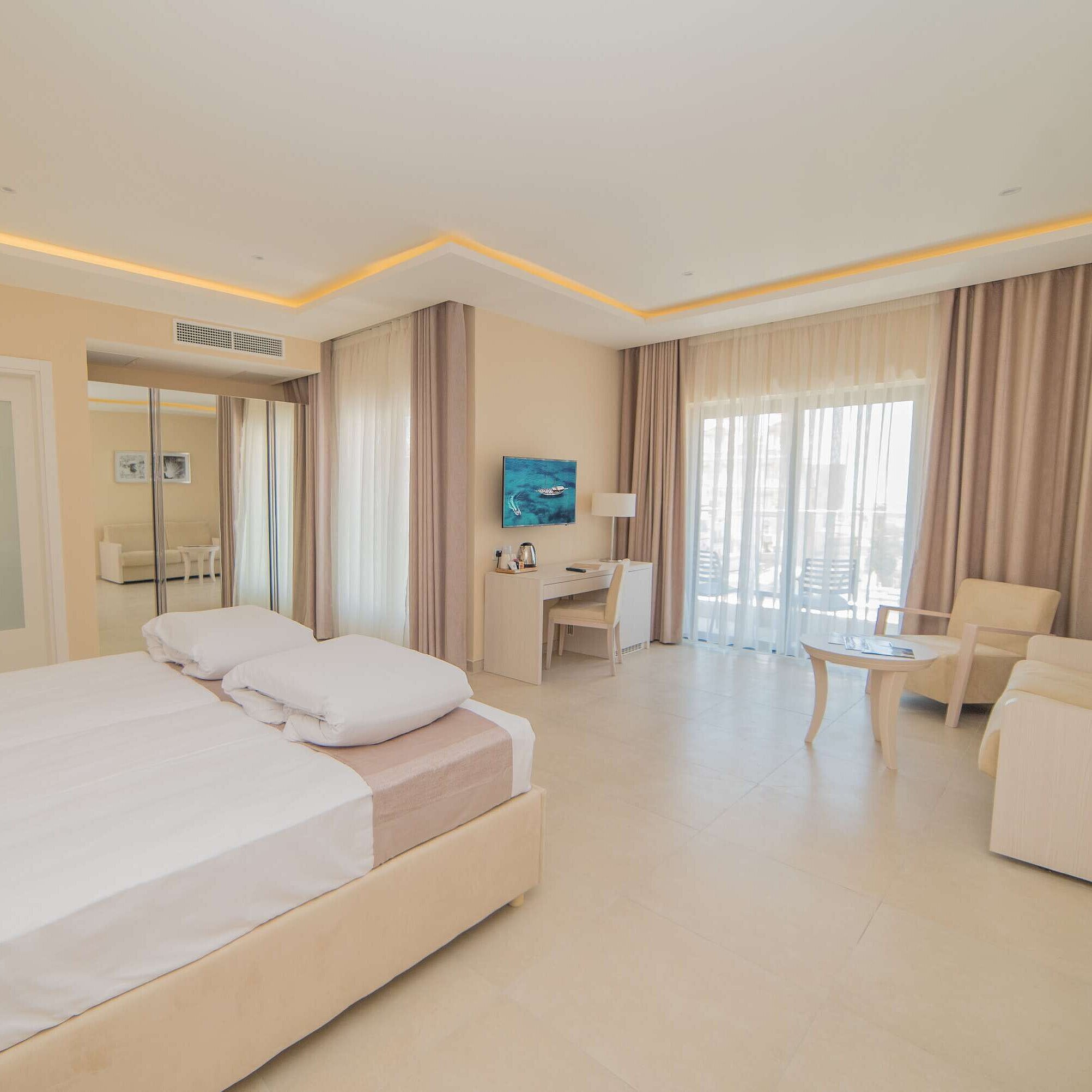 Spacious hotel room with sleeping area, living space, balcony and modern design
