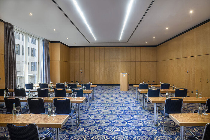 Meeting room Salon IV in the Maritim proArte Hotel Berlin with tables, chairs and lectern.