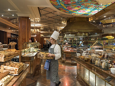 Breakfast buffet at Maritim Hotel Bremen with fresh bread rolls, bread,and a selection of breakfast dishes,attended by a chef