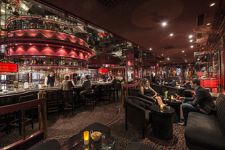 Guests enjoying drinks in stylish red-lit hotel bar at Maritim Hotel Stuttgart