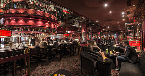 Guests enjoying drinks in stylish red-lit hotel bar at Maritim Hotel Stuttgart